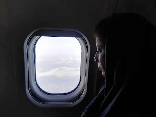 Muslim woman in hijab traveling by airplane