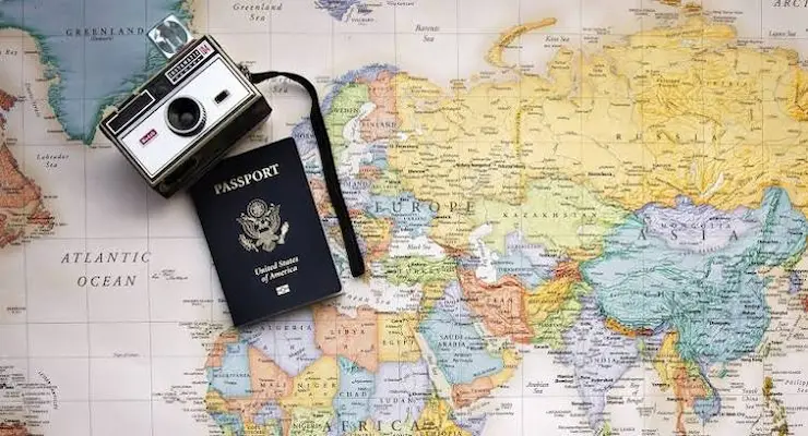 Passport and camera on a world map for travel planning