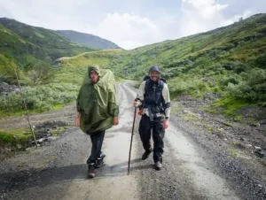 Two pilgrims walking along a mountain pilgrimage route